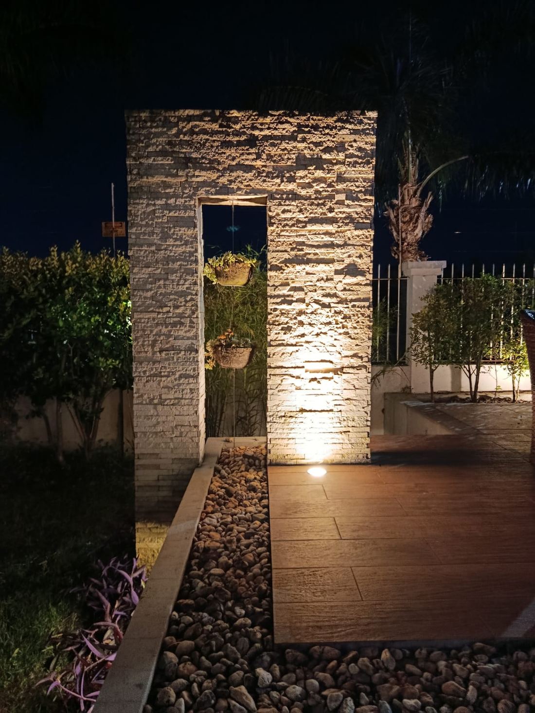 Portal de pedra com luz de destaque no jardim